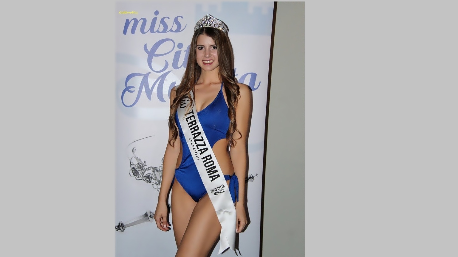 Selene Rossi posa con eleganza indossando la fascia ufficiale e la corona di vincitrice, sorridendo all'obiettivo subito dopo la proclamazione come la più bella della selezione di Miss Città Murata 2019.