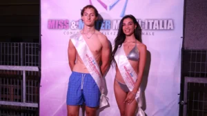 Fotografia del Mister e della Miss Motteggiana finalisti di Miss & Mister Model Italia, posizionati davanti al pannello ufficiale del concorso. Il Mister indossa costume da passerella e la fascia “Mister Motteggiana 2023 Finalista”, mentre la Miss indossa un bikini argentato con la fascia “Miss Motteggiana 2023 Finalista”. Entrambi posano frontalmente con espressione sorridente. Lo sfondo riporta la grafica “Miss & Mister Model Italia Concorso di Bellezza Nazionale”. L’immagine documenta i due vincitori della selezione di Motteggiana.