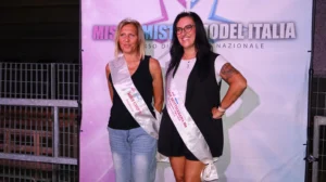 Fotografia di due concorrenti Lady finaliste di Miss & Mister Model Italia, ritratte davanti al pannello ufficiale del concorso. Entrambe indossano corone e fasce bianche con i rispettivi titoli, posando in abbigliamento da passerella. La concorrente di sinistra porta la fascia “Miss Chip’s Finalista”, mentre quella di destra indossa la fascia “Lady Motteggiana Finalista”. Lo sfondo riporta la grafica “Miss Mister Model Italia Concorso di Bellezza Nazionale”. L’immagine rappresenta il momento di premiazione delle due Lady durante la selezione di Motteggiana.