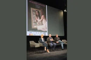 Conferenza stampa del cortometraggio Un Silenzio Soffocato presso il Cinema Anica di Roma. Sul palco sono seduti tre rappresentanti del progetto cinematografico durante l'incontro con il pubblico e la stampa successivo alla proiezione. Alle loro spalle un grande schermo mostra la locandina ufficiale del film diretto da Andrea Rigon, con i nomi degli interpreti principali e l'immagine simbolica utilizzata per la promozione dell'opera. La fotografia racconta uno dei momenti centrali dell'evento romano, durante il quale regista e cast hanno illustrato il percorso creativo del cortometraggio e approfondito la delicata tematica della violenza psicologica affrontata dalla produzione.