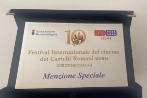 Targa ufficiale esposta in una cornice nera che celebra il riconoscimento ottenuto dal cortometraggio Un Silenzio Soffocato al Festival Internazionale del Cinema dei Castelli Romani 2026. Al centro della targa compare la dicitura "Menzione Speciale" nella sezione dedicata ai cortometraggi. Nella parte superiore sono visibili il logo dell'Associazione Puntoevirgola, il simbolo della decima edizione del festival e il logo del CROFFI. L'immagine documenta il prestigioso riconoscimento assegnato all'opera diretta da Andrea Rigon nell'ambito della decima edizione del festival cinematografico dei Castelli Romani.